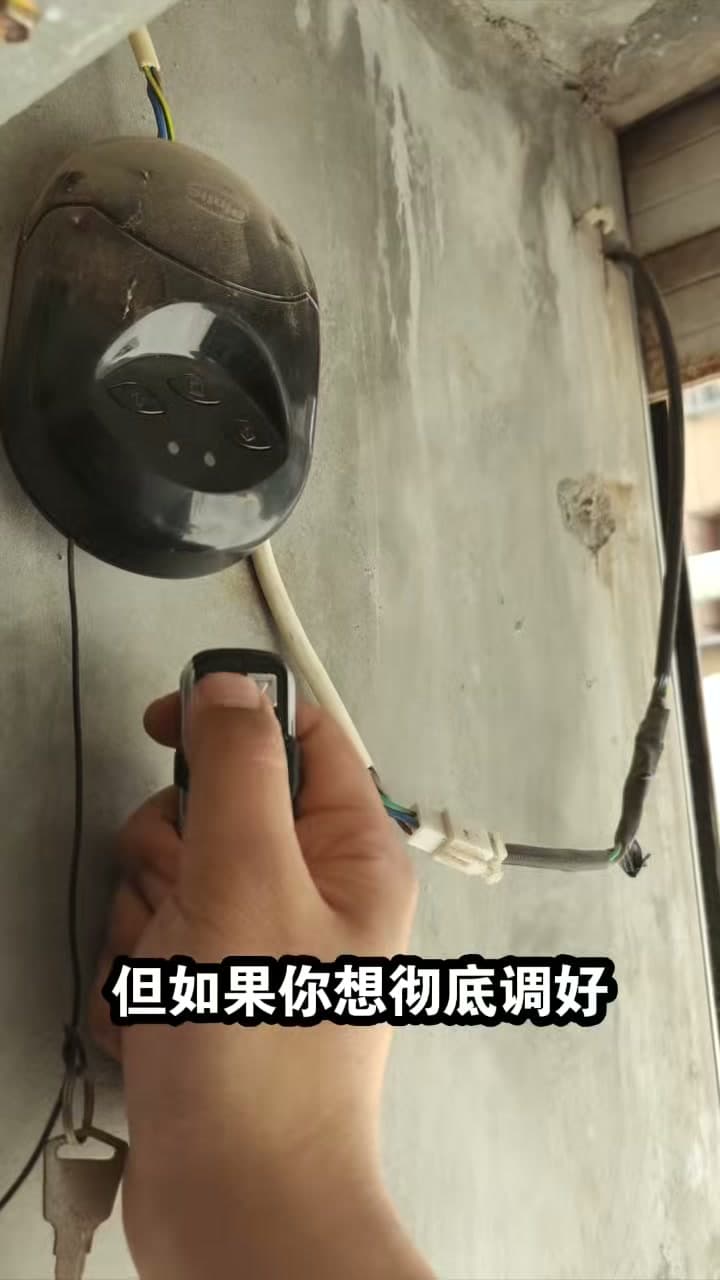 师傅在卷帘门控制器旁使用拷贝码遥控器重新学习按键